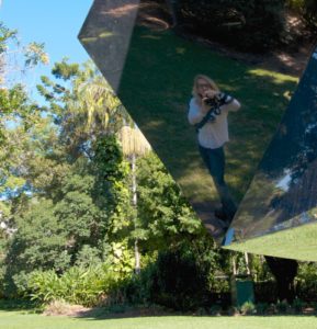 Katrina Coombs reflection from a mirrored sculpture in a botanical gardens